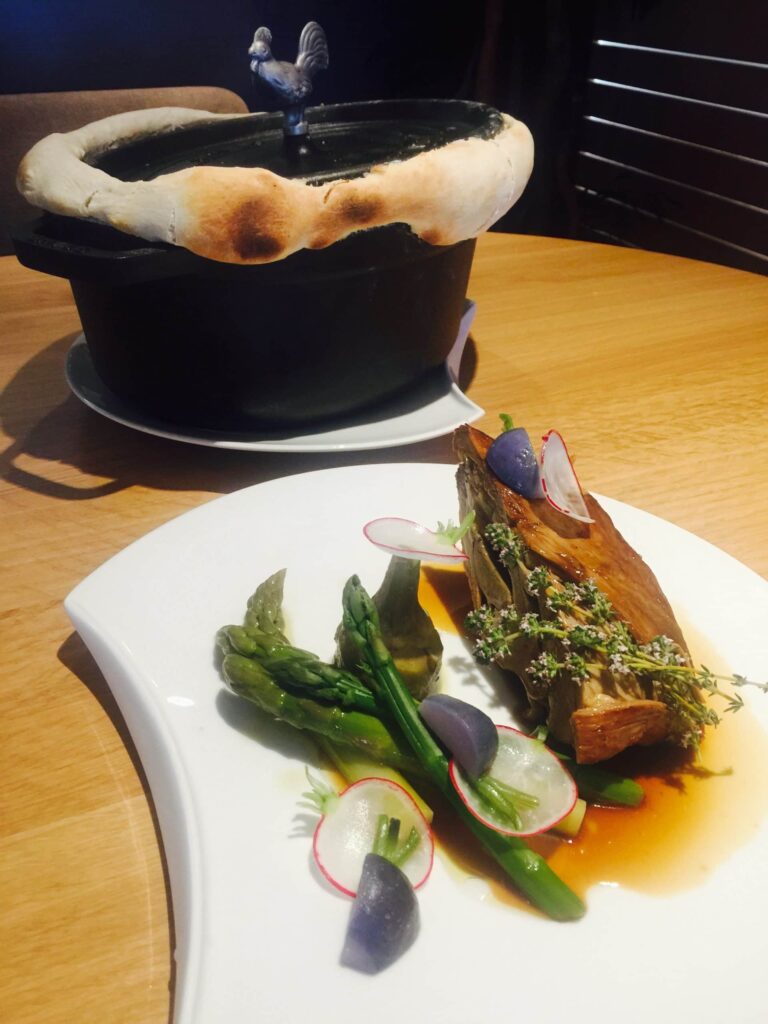 Épaule d’agneau de Sisteron cuite en cocotte lutée, artichaut violet, asperges vertes et radis