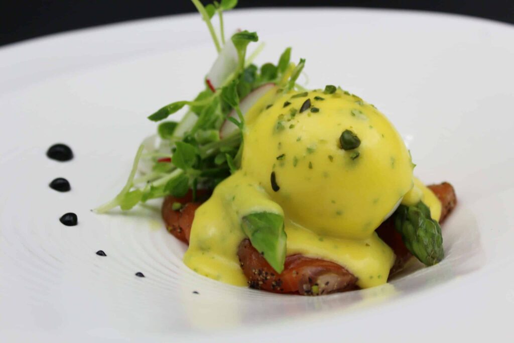 Œuf parfait aux asperges et saumon confit, sauce béarnaise au Gombawa et pistaches